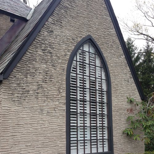 outside facade of stone home with plantation shutters